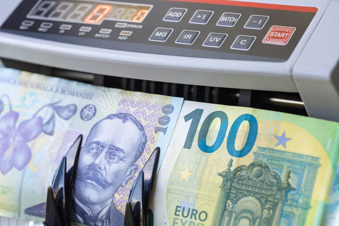 Bancnote în lei și o bancnotă euro la numărarea numerarului